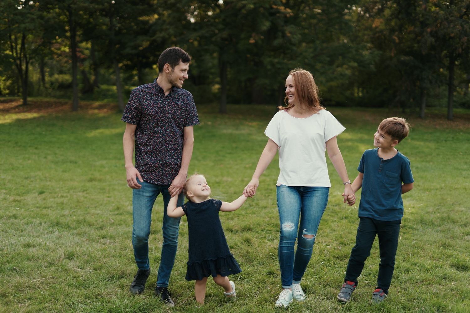 Happy family holding hands while walking the park